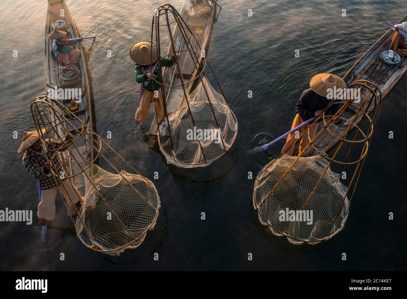 Myanmar, estado de Shan, lago Inle, pescadores que pescan con técnicas tradicionales de pesca al atardecer Foto de stock