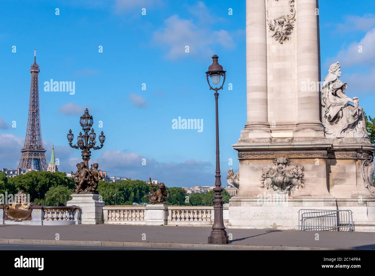 Francia. Día soleado de verano en París. Columna histórica y faroles en el puente Alexandre III a través del río Sena. Torre Eiffel en la distancia Foto de stock