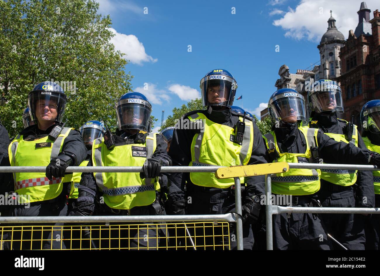La policía antidisturbios en Whitehall tras las barreras, impidiendo que los partidarios de la primera extrema derecha de Gran Bretaña se enfrenten con vidas negras importan a los manifestantes antirracistas. Foto de stock