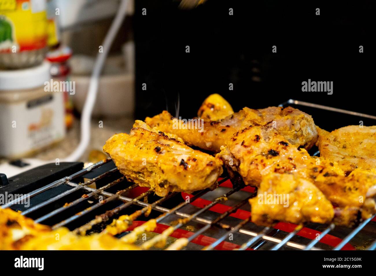 pollo asado sobre una parrilla eléctrica caliente con varillas calientes en  la barbacoa de casa Fotografía de stock - Alamy