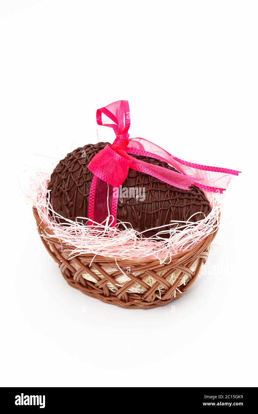 Huevo de chocolate en una hermosa cesta de mimbre con cinta roja para  regalo. Celebración del día de la Madre, día de San Valentín y Pascua  Fotografía de stock - Alamy