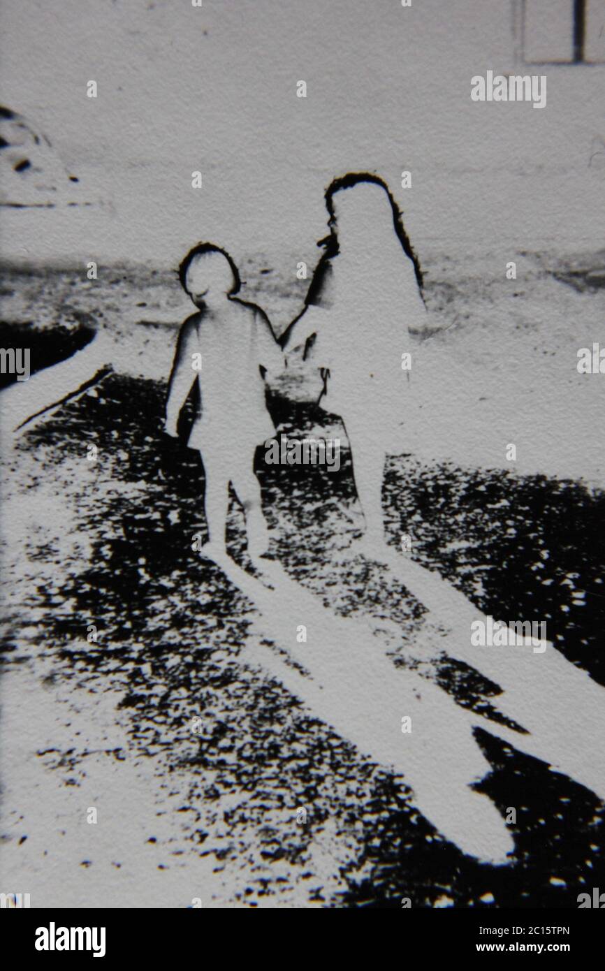 Fotografía extrema en blanco y negro de la cosecha de los 70 de dos chicas que caminan lejos de la cámara. Foto de stock