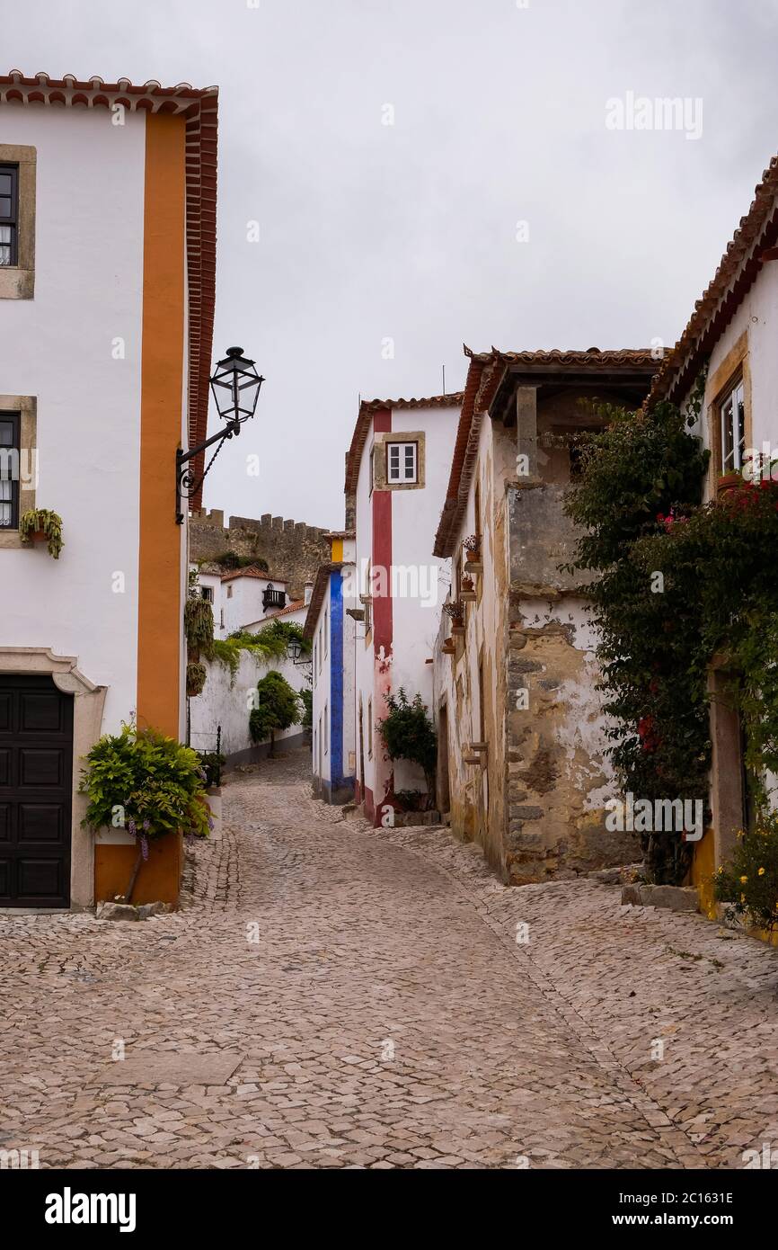 Óbidos, Portugal - famoso destino turístico por su distinguida arquitectura e historia - Casas tradicionales de colores brillantes con flores Foto de stock