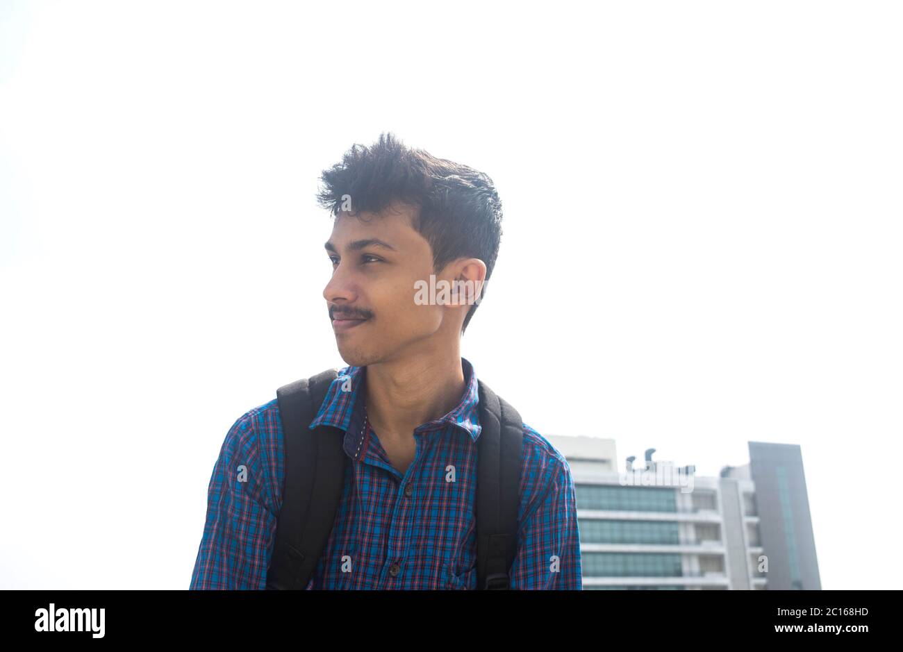 vista lateral de un joven adolescente en una mochilas .fondo corporativo de la compañía. Foto de stock