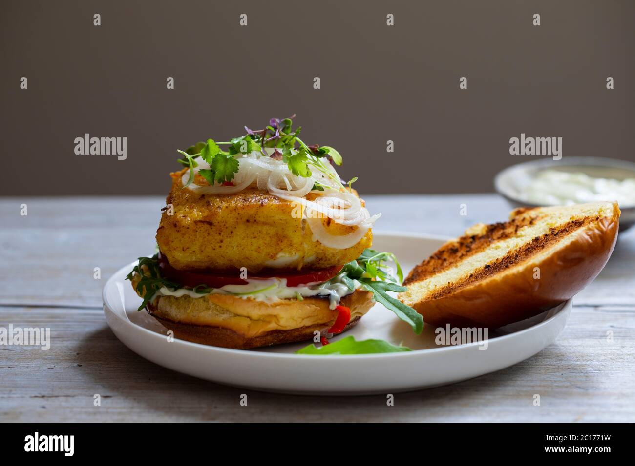 Hamburguesa de pescado cúrcuma en bollo de brioche Foto de stock