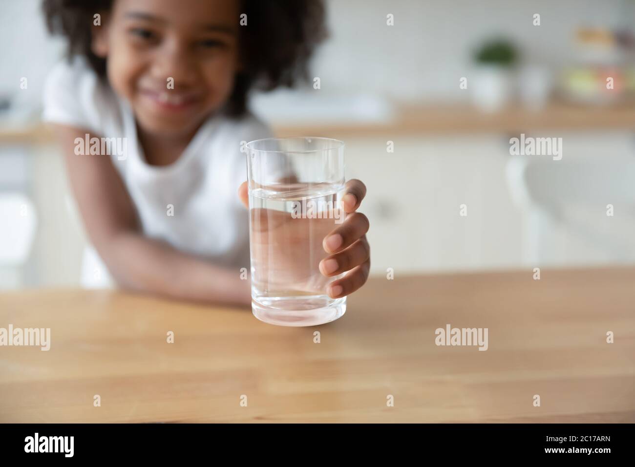 Niña africana sostiene un vaso de agua imagen de cierre Foto de stock