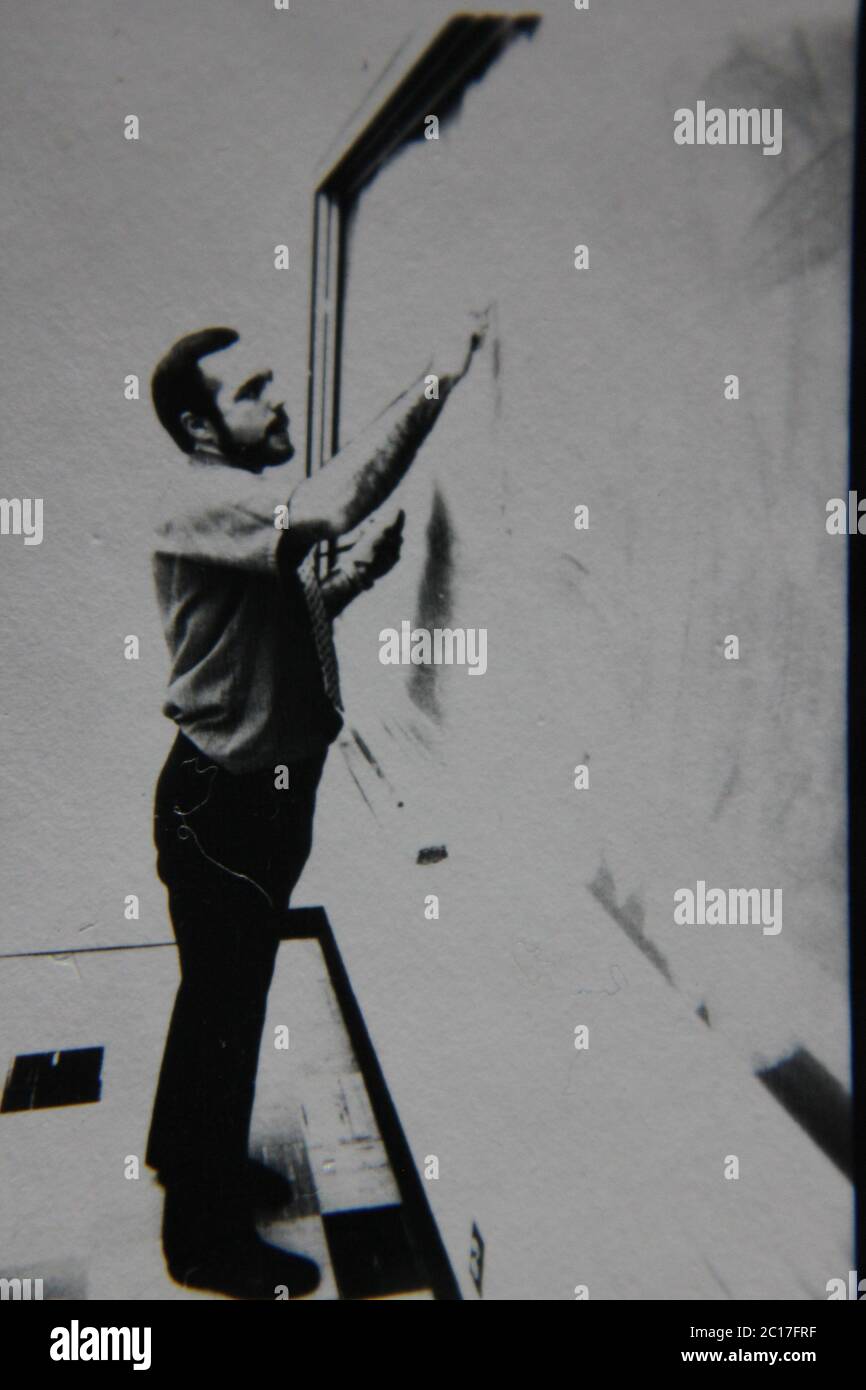 Fotografía extrema de los años 70 de la vendimia fina en blanco y negro de un profesor parado en la pizarra y escribiendo en ella. Foto de stock