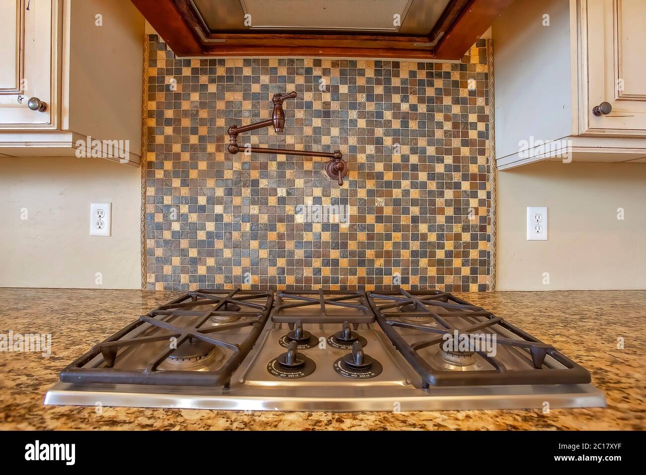 Parrilla y campana de escape dentro de la cocina con grifo en la pared de  salpicadura de azulejos Fotografía de stock - Alamy