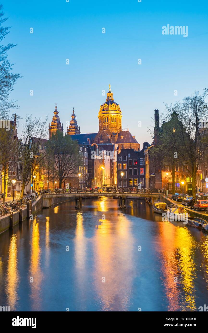 Noche en Amsterdam con la Basílica de San Nicolás en la ciudad de Amsterdam, Holanda Foto de stock