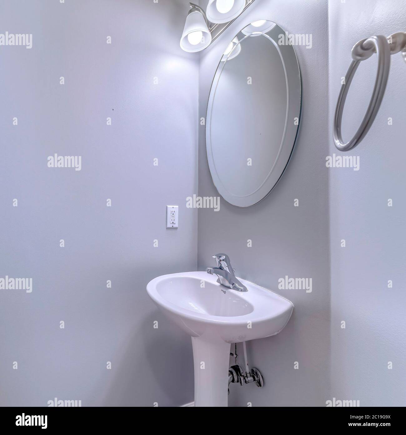 Marco cuadrado Interior de baño con aplique y espejo ovalado sobre lavabo  independiente con pedestal Fotografía de stock - Alamy