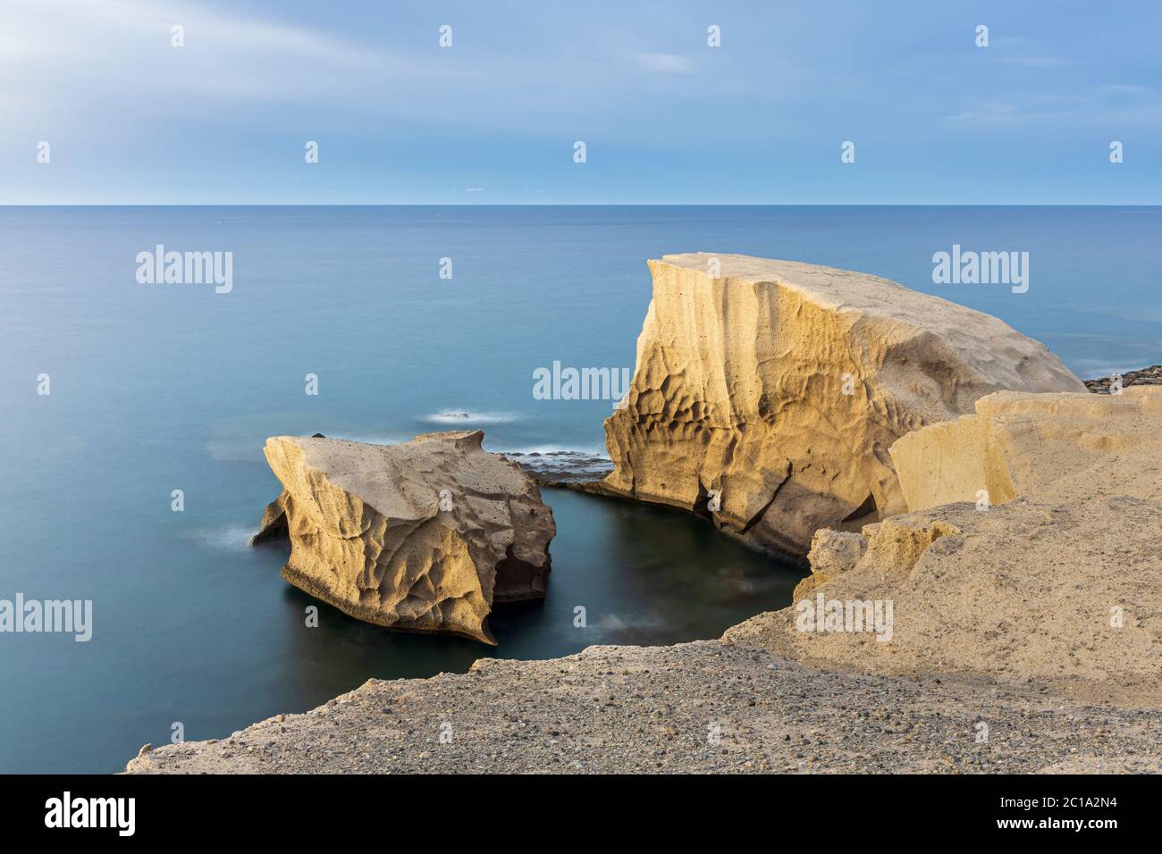Fotografía de larga exposición con rocas de color arena en el océano atlántico en la costa por Tajao, Tenerife, Islas Canarias, España Foto de stock