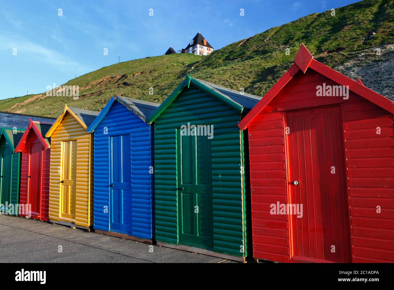 Coloridas cabañas de playa bajo el paseo marítimo del norte, Whitby, Yorkshire del Norte, Inglaterra, Reino Unido, Europa Foto de stock