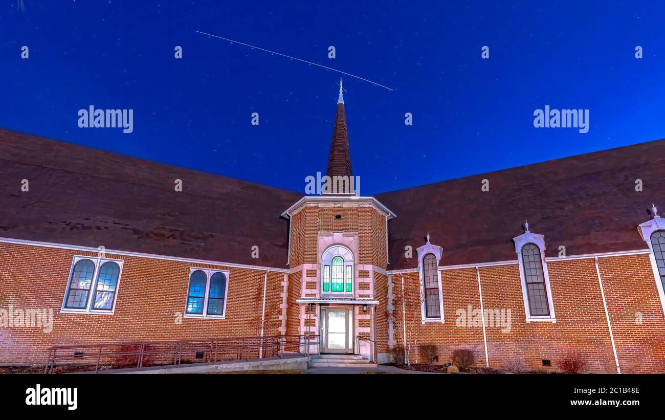 Panorama Vista frontal de una hermosa iglesia de ladrillo en Provo Utah con cielo azul profundo sobre la cabeza Foto de stock