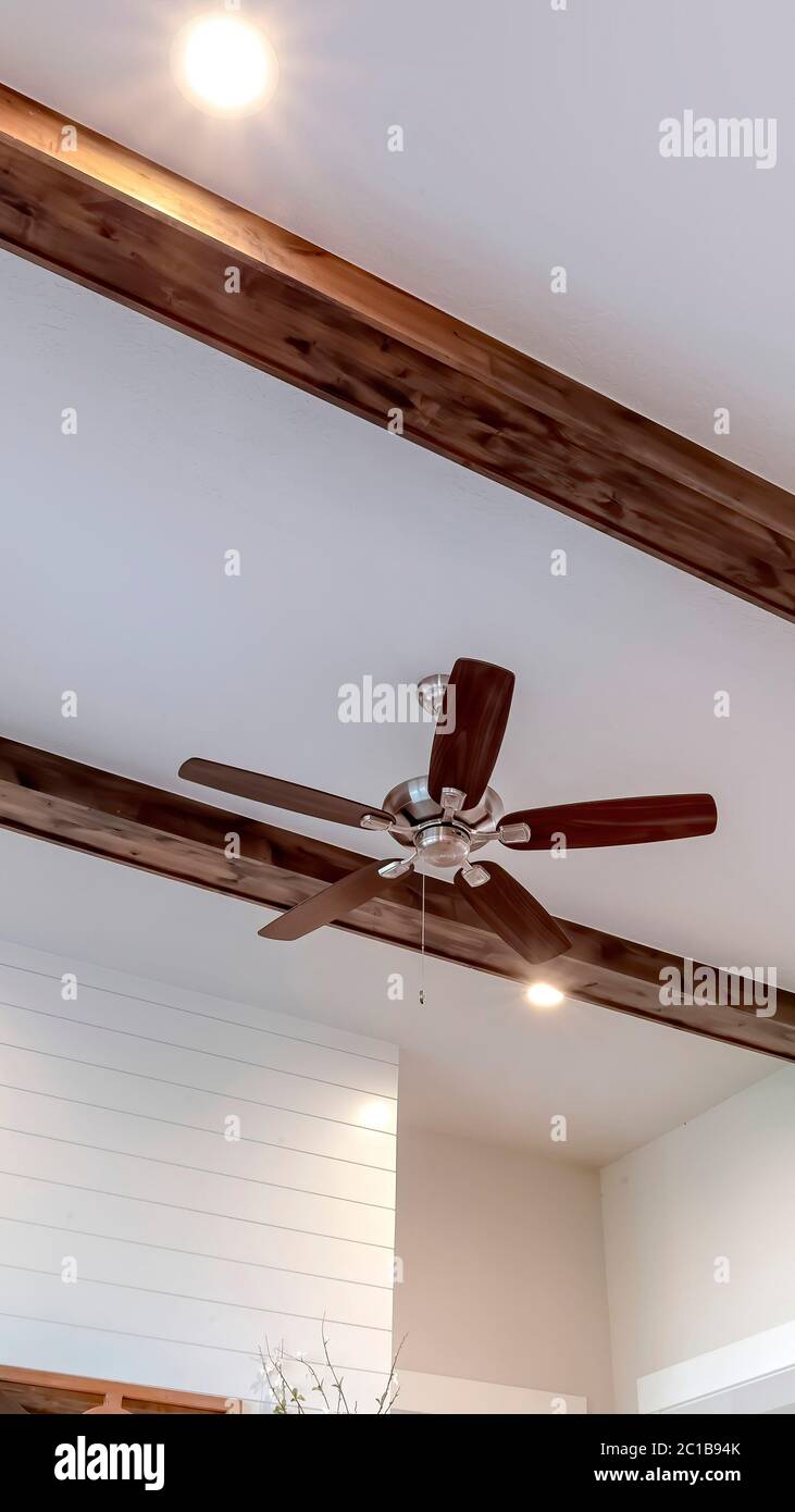 Vigas de madera verticales y bombillas empotradas con ventilador de techo y  luces en el centro Fotografía de stock - Alamy