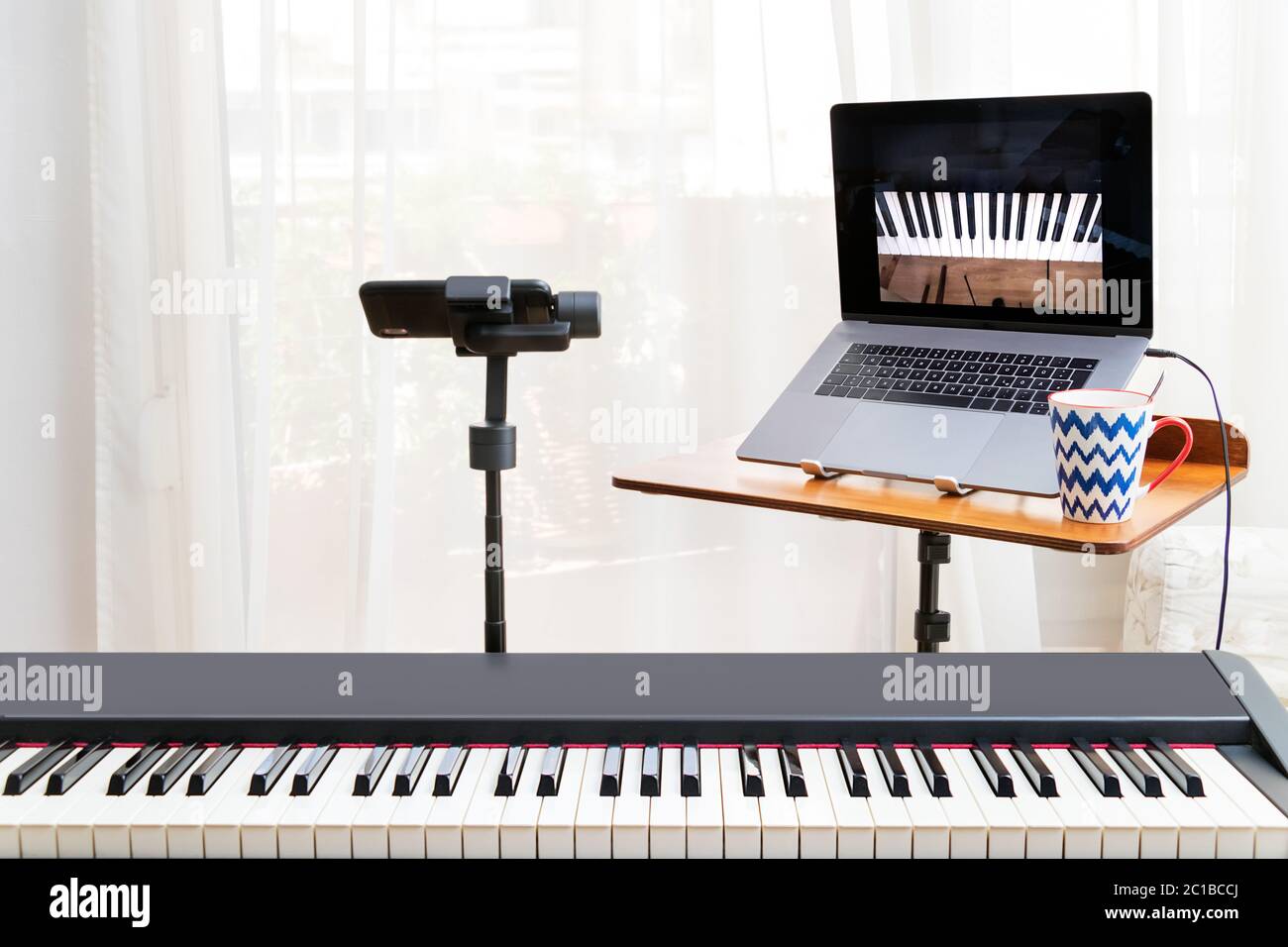 Piano en línea con un ordenador portátil, un teclado de piano y un  smartphone en un gimbal como cámara Fotografía de stock - Alamy