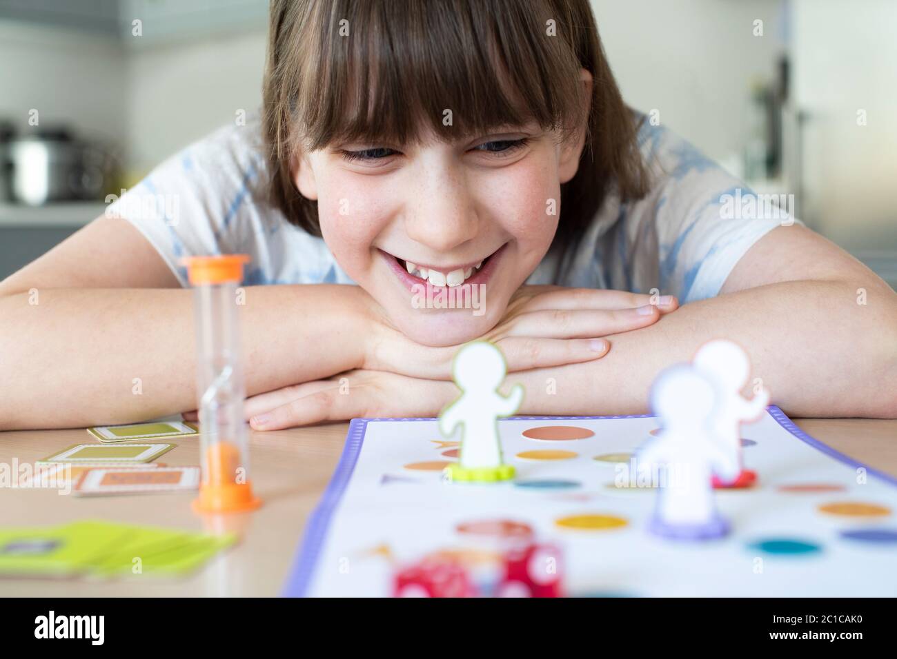 Sonriendo Chica jugando Juego de Mesa genérico en casa Foto de stock