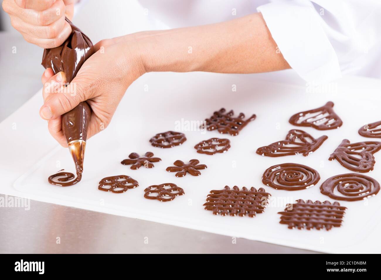 Chef haciendo figuras con chocolate para decorar una torta Fotografía de  stock - Alamy