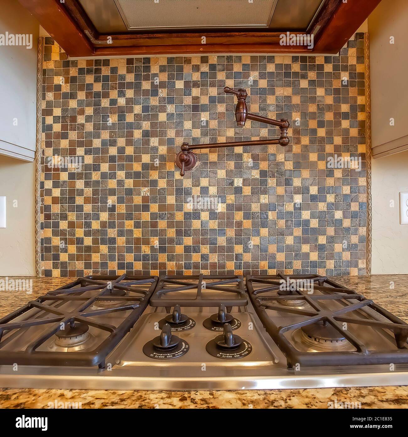 Parrilla de cocinar cuadrada y campana de escape dentro de la cocina con  grifo en la pared de azulejos Fotografía de stock - Alamy