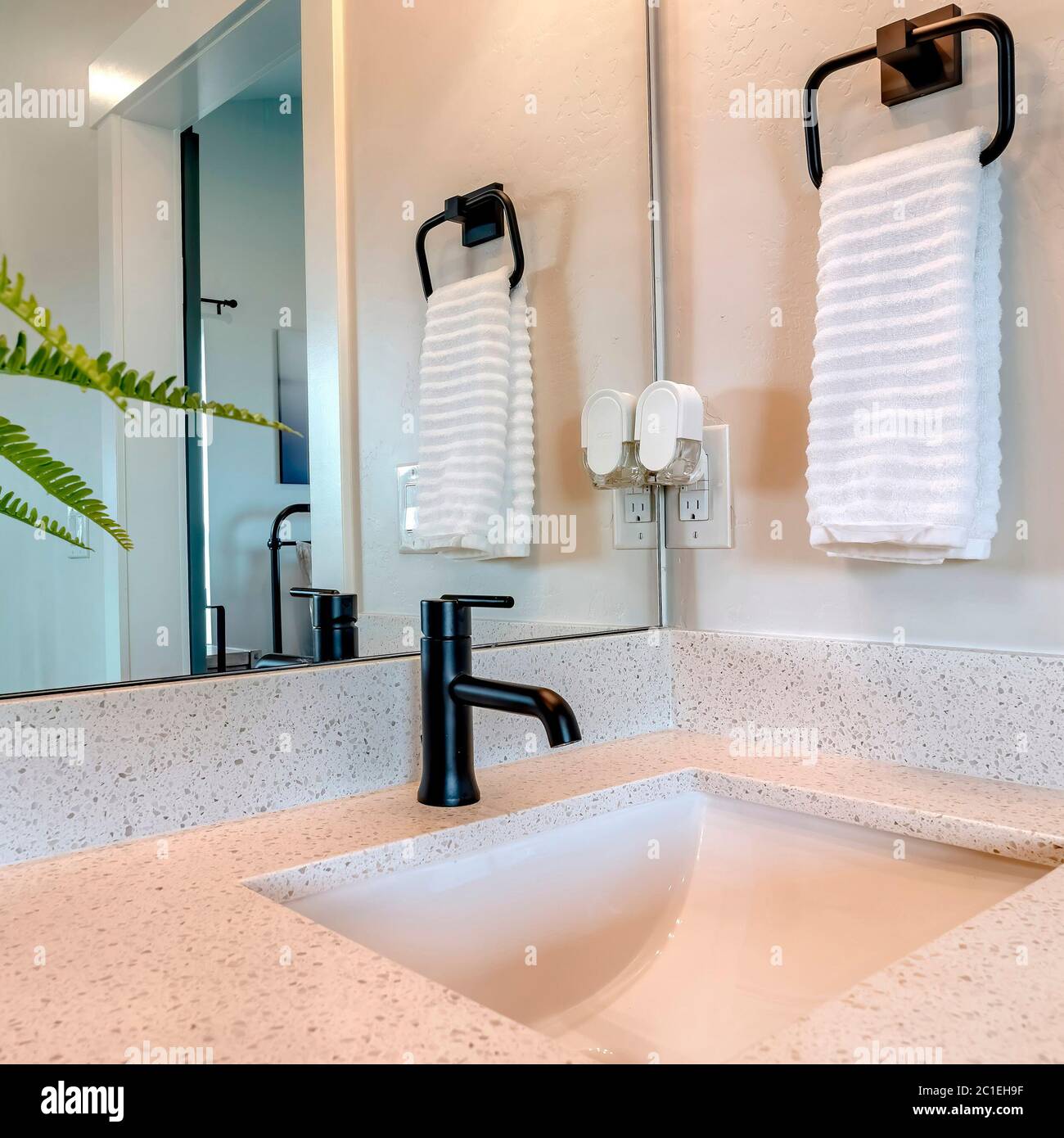 Marco cuadrado Baño lavabo y grifo contra la pared con toma de toalla  colgada e interruptor de luz Fotografía de stock - Alamy