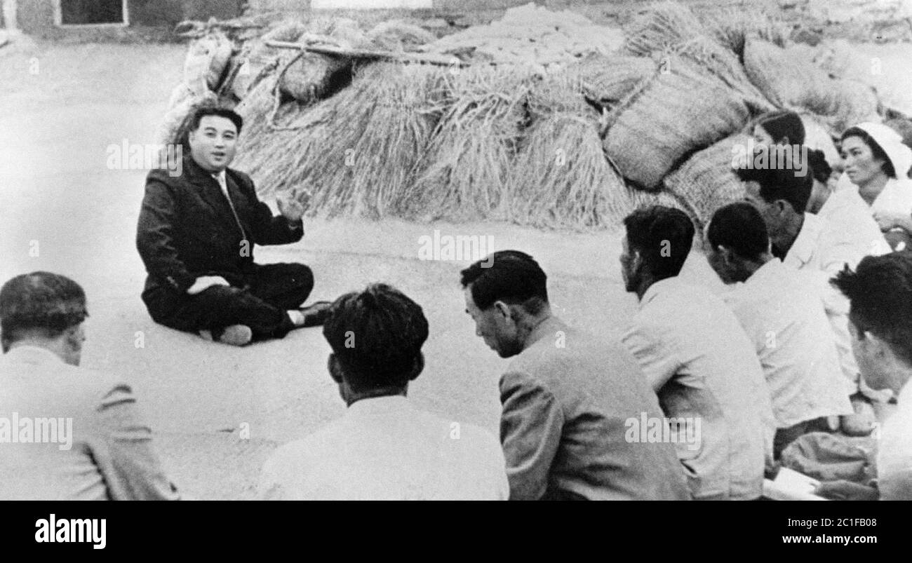 Foto de propaganda de la Agencia de Noticias de Corea del Norte. El líder comunista Kim Il Sung habla con un agricultor de Qingshanli, condado de Kangso, Pyongya del Sur Foto de stock