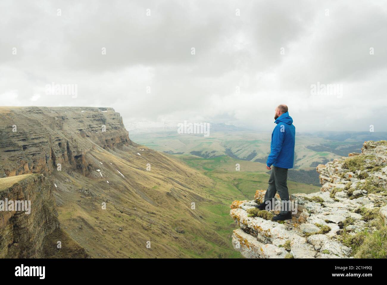 Retrato de un joven senderismo masculino en las montañas con ropa roja  explorando un lugar nuevo. Viajero barbudo hombre trekking y montañismo  durante su viaje. Viajes, personas, deporte y estilo de vida