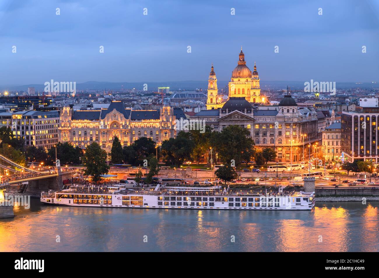 Un ferry pasa por la costa este del río Danubio en Budapest, pasando el edificio del Parlamento Foto de stock