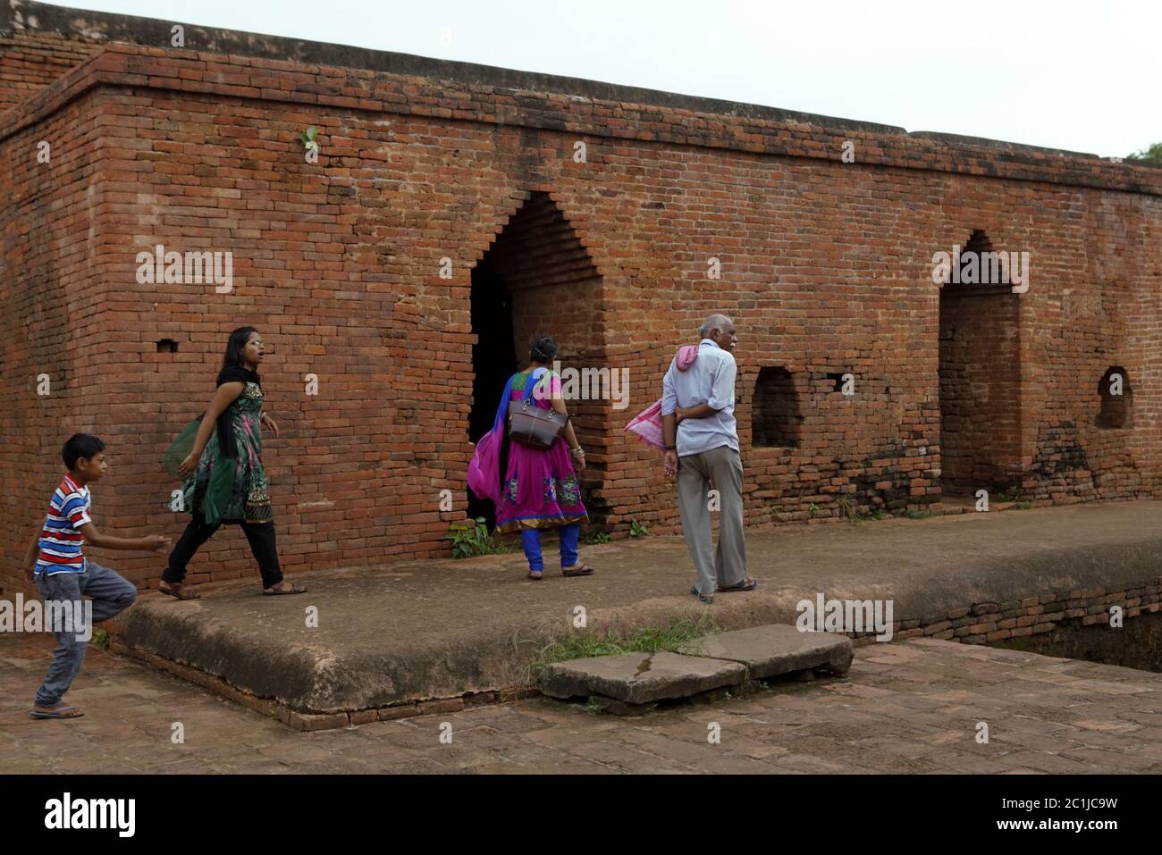 Un guía y una visita familiar local a uno de los monasterios excavados dentro del antiguo complejo universitario budista de Nalanda en Bihar, India. Foto de stock