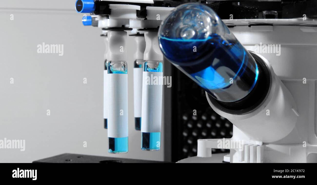 Equipo de laboratorio de pruebas para analizar viales con líquido azul Foto de stock