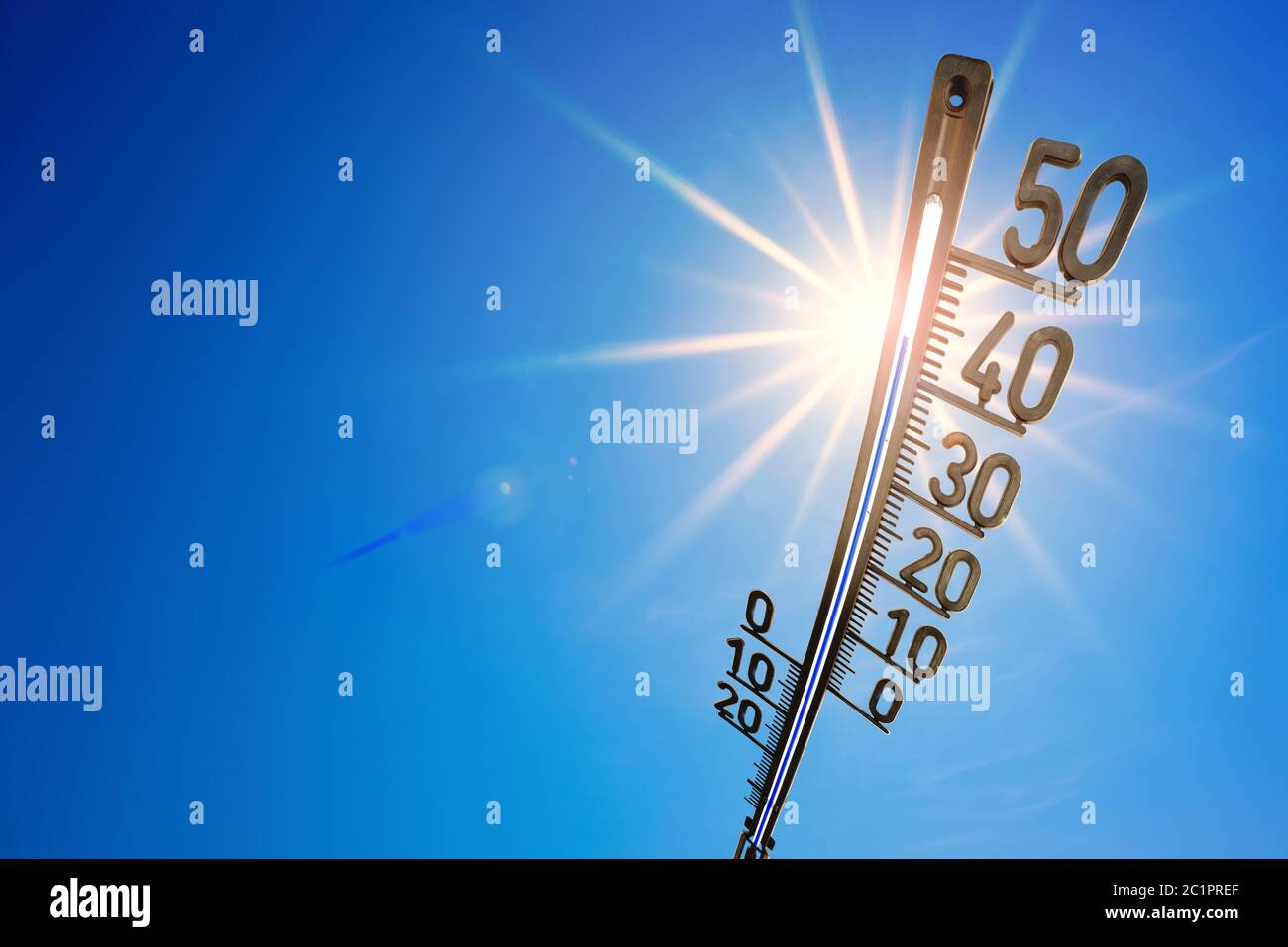 Verano caliente o fondo de ola de calor, sol brillante sobre cielo azul con termómetro Foto de stock