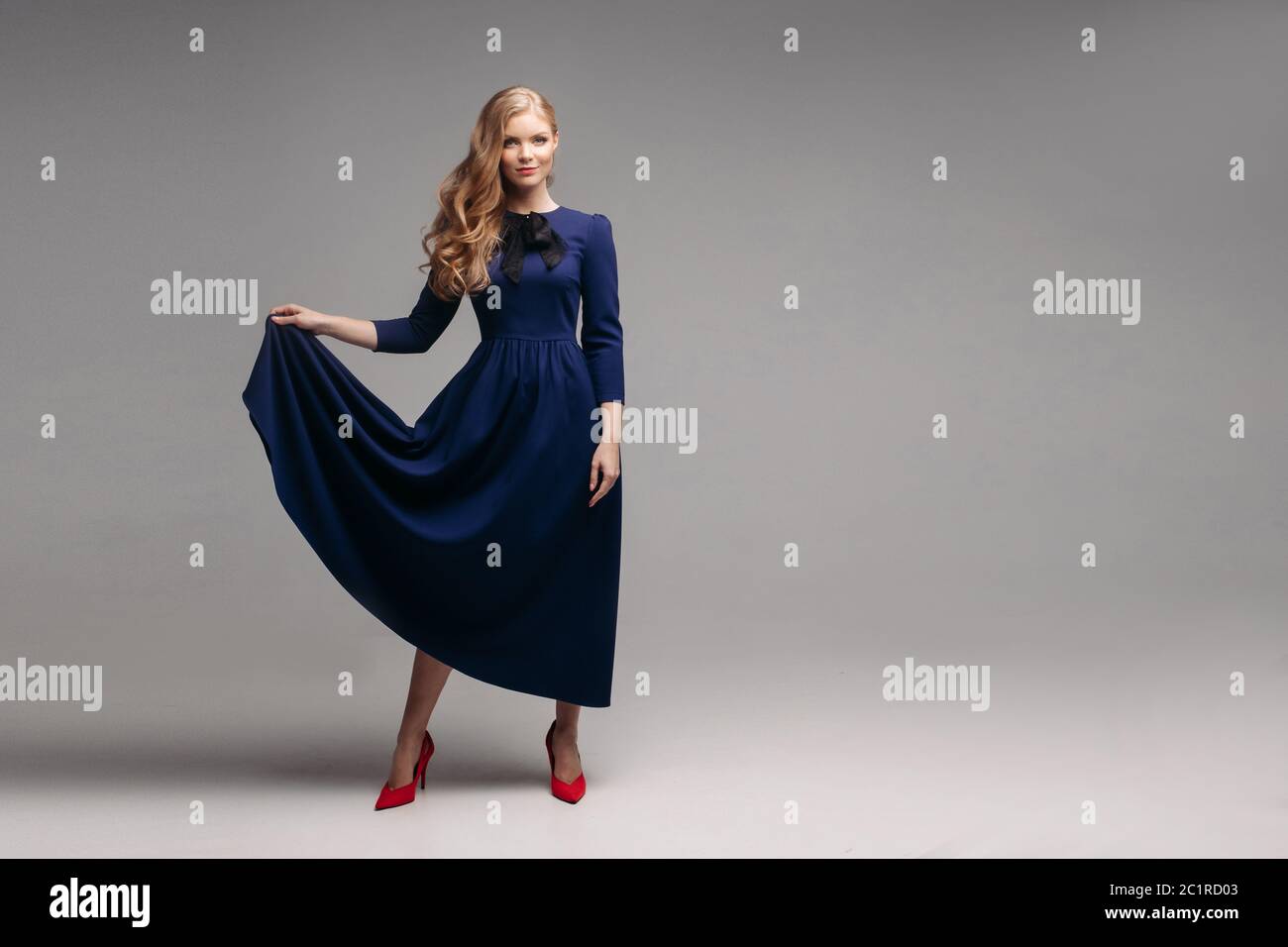 Impresionante modelo slim en un brillante vestido azul y negro talones. Foto de stock