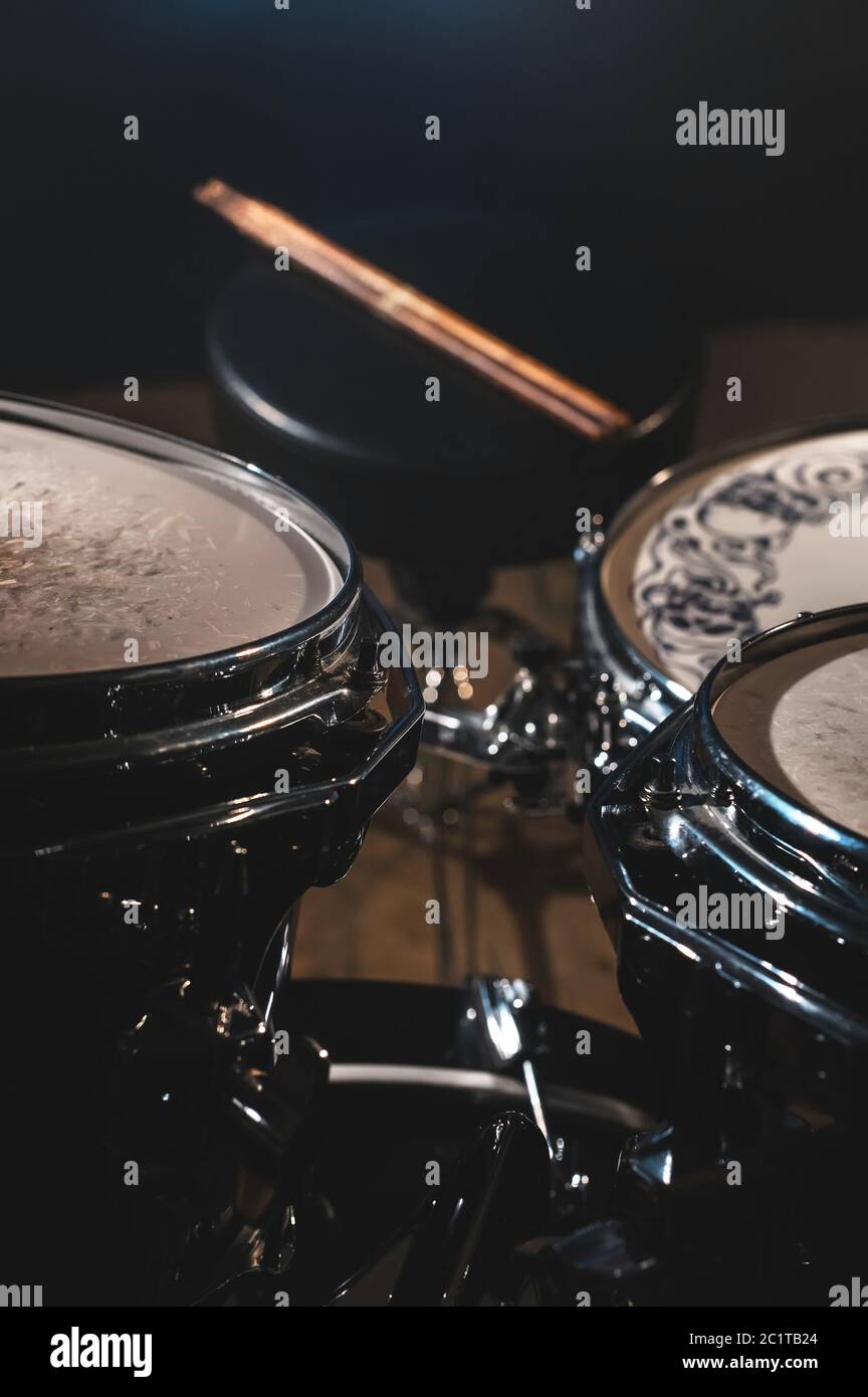 Vista de un conjunto de tambores y Drumsticks en un estudio oscuro.  Barriles de tambor negro con acabado cromado. El concepto de actuación en  directo Fotografía de stock - Alamy