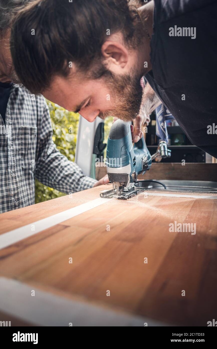 Hombre usando una sierra de calar para cortar una encimera de madera  Fotografía de stock - Alamy