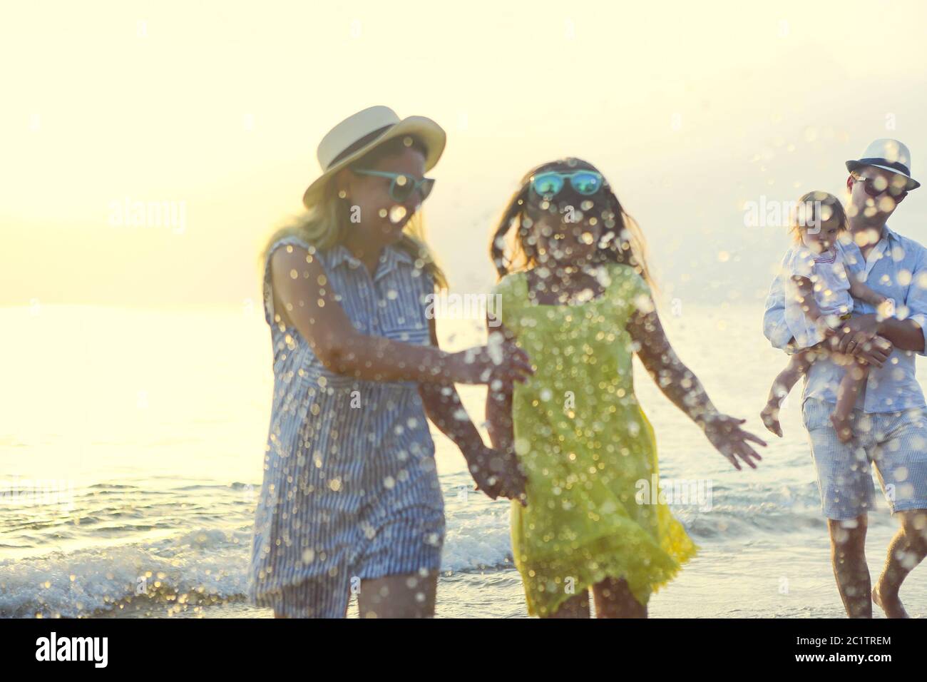 Feliz familia joven diviértase en la playa correr y saltar Foto de stock