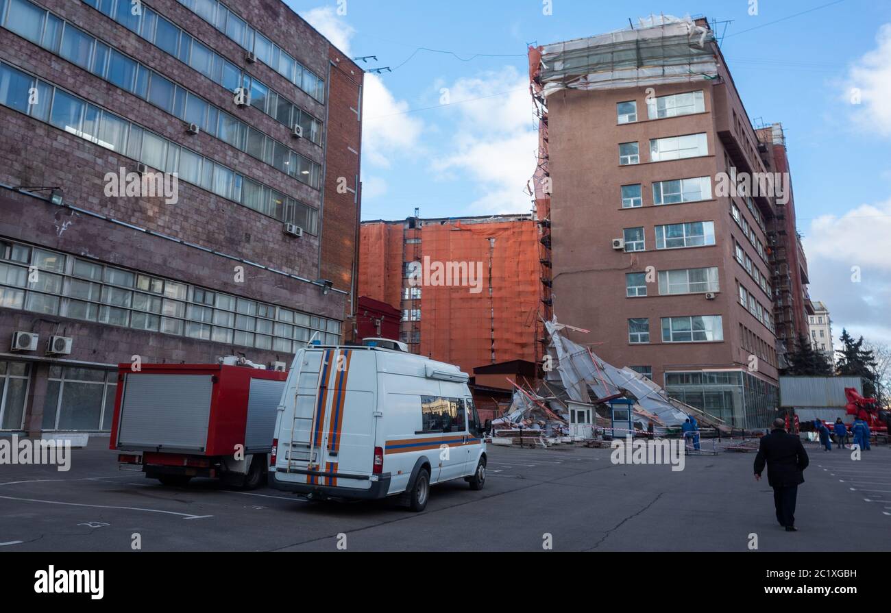 Un coche del Ministerio de situaciones de emergencia en el sitio de andamios se derrumbó de un fuerte viento cerca de un edificio reconstruido de varios pisos en TH Foto de stock