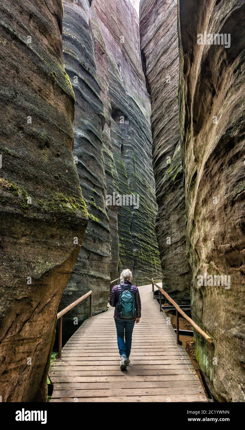 Mujer mayor hiker dentro del cañón de ranura en las rocas de Adrspach, Reserva Natural Nacional de las rocas de Adrspach-Teplice, Sudetes centrales, República Checa Foto de stock