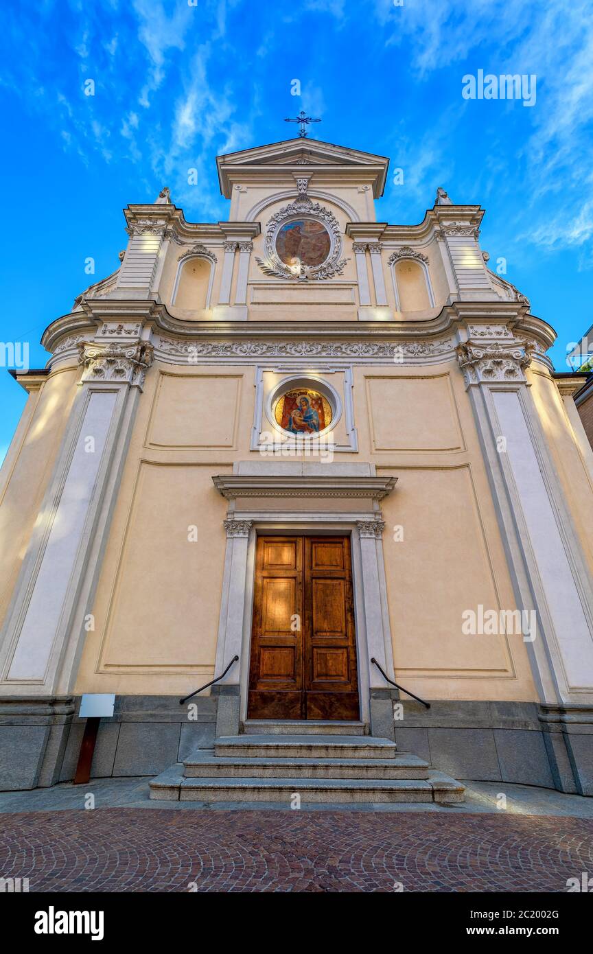 Fachada de la iglesia católica de San Giovanni Battista bajo el cielo azul en el casco antiguo de Alba en Piamonte, norte de Italia (vista de ángulo bajo, composición vertical). Foto de stock