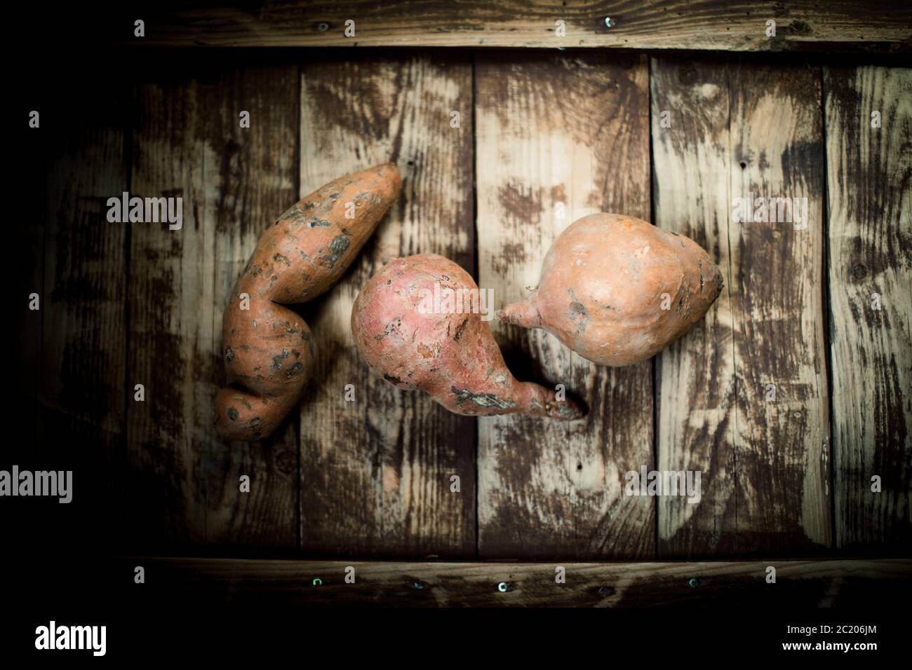 batatas crudas sobre una mesa de madera, vista superior Foto de stock