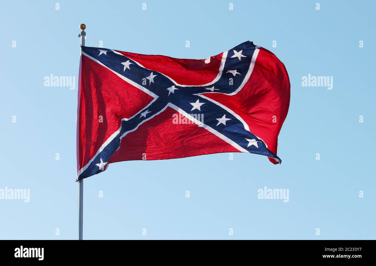 Bandera rebelde confederada que ondea el viento contra el fondo azul del cielo en Charleston, Carolina del Sur, EE.UU. Foto de stock