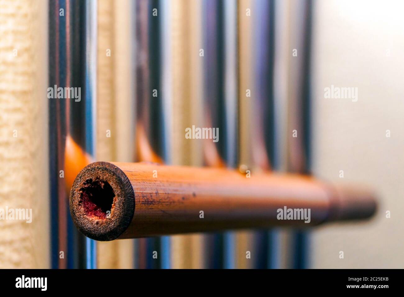 Campanas tubulares metálicas con tubo de bambú cuelgan en la pared y crean la música del viento. Foto de stock