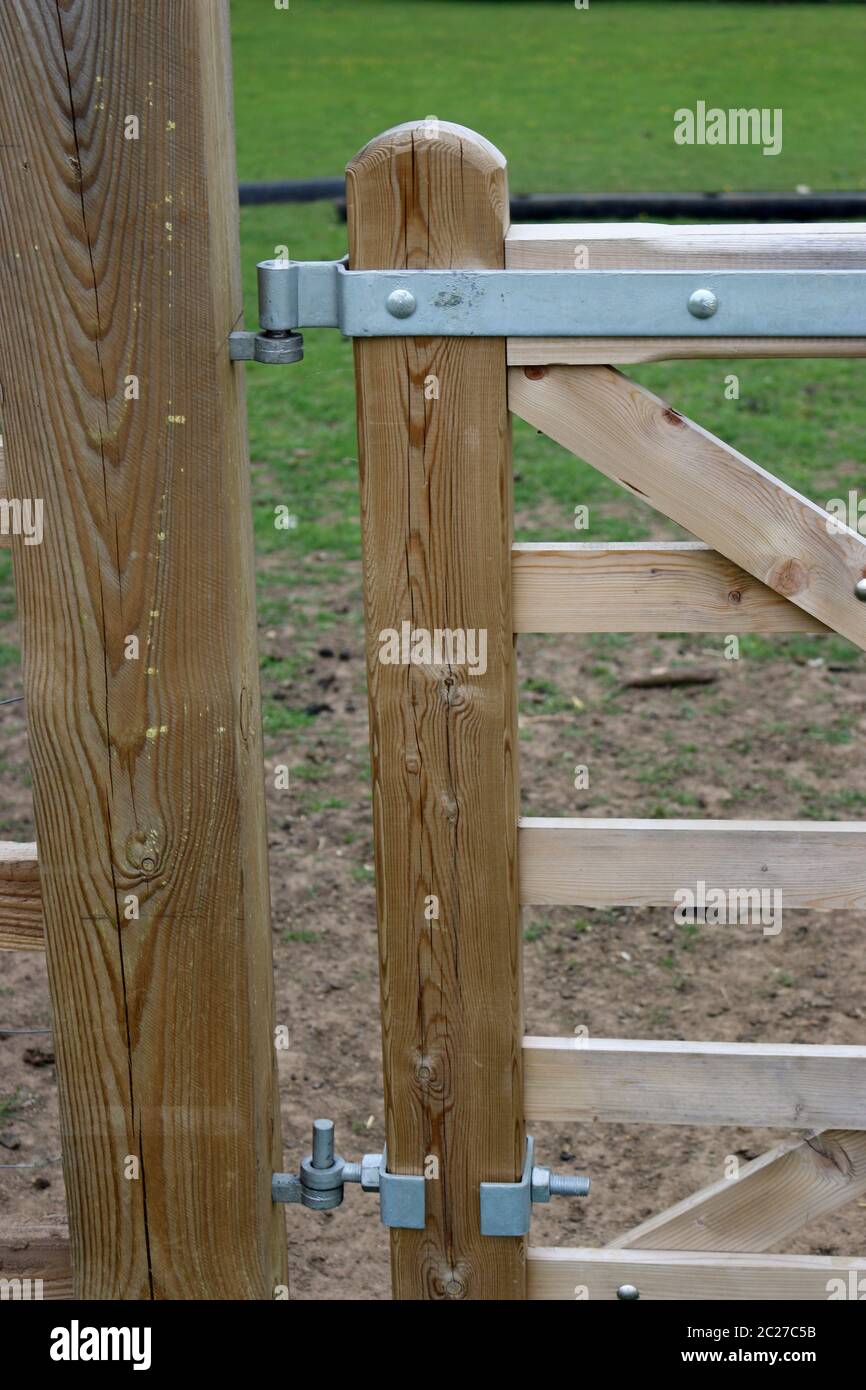 Recientemente erigida cinco barras de madera grande puerta de campo  conectados a un poste de madera mostrando las bisagras con un campo de  hierba en el fondo Fotografía de stock - Alamy