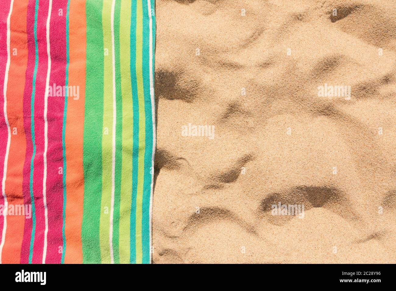 Toalla de playa en playa tropical de arena Foto de stock