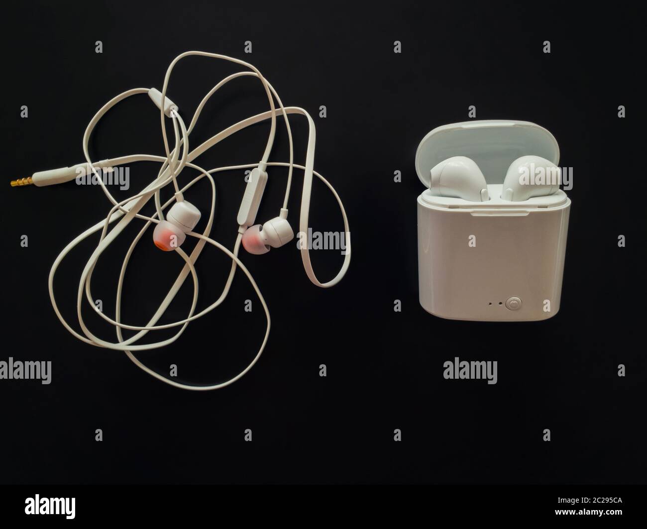 Comparación entre auriculares con cables enredados versus auriculares  inalámbricos para escuchar música. Los pros y los contras, frente al  contrario. El desarrollo de la tecnología te Fotografía de stock - Alamy
