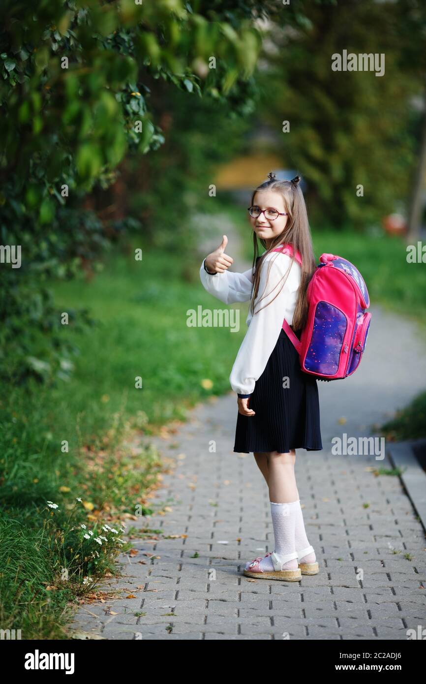 Colegiala con una mochila. Feliz la ni a va a la escuela. Hijo de