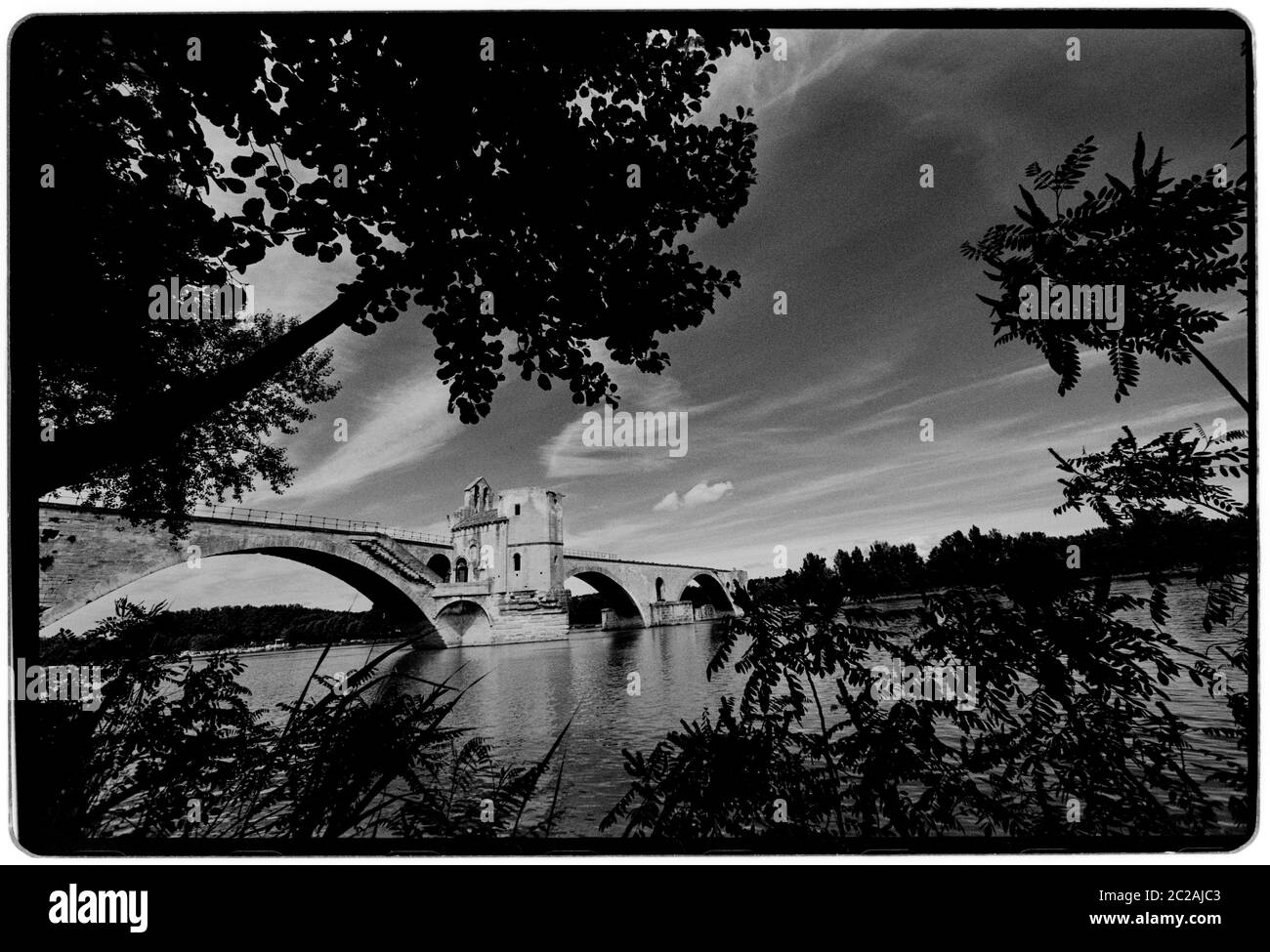 Puente de Aviñón. El Pont Saint-Bénézet, Pont d'Avignon, 1988 Wikipeadia: El Pont Saint-Bénézet, también conocido como el Pont d'Avignon, es un famoso puente medieval en la ciudad de Avignon, en el sur de Francia. Entre 1177 y 1185 se construyó un puente de madera que abarca el Ródano entre Villeneuve-lès-Avignon y Avignon. Este puente fue destruido cuarenta años más tarde en 1226 durante la cruzada albigense cuando Luis VIII de Francia sitió a Aviñón. A partir de 1234 el puente fue reconstruido con 22 arcos de piedra. El puente de piedra tenía una longitud de 900 m (980 yd) y sólo 4.9 m (16 pies) de ancho Foto de stock