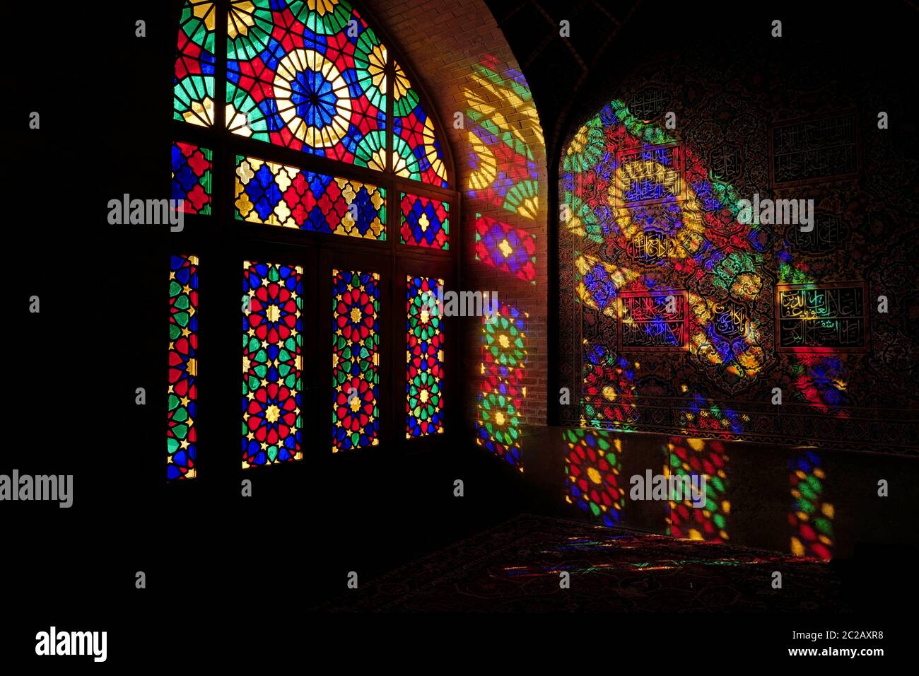 La luz de la mañana entra a través de las coloridas ventanas de vidrio de la histórica mezquita Masjed-e-Nasir-al-Molk, también conocida como la Mezquita Rosa, en Shiraz. Foto de stock