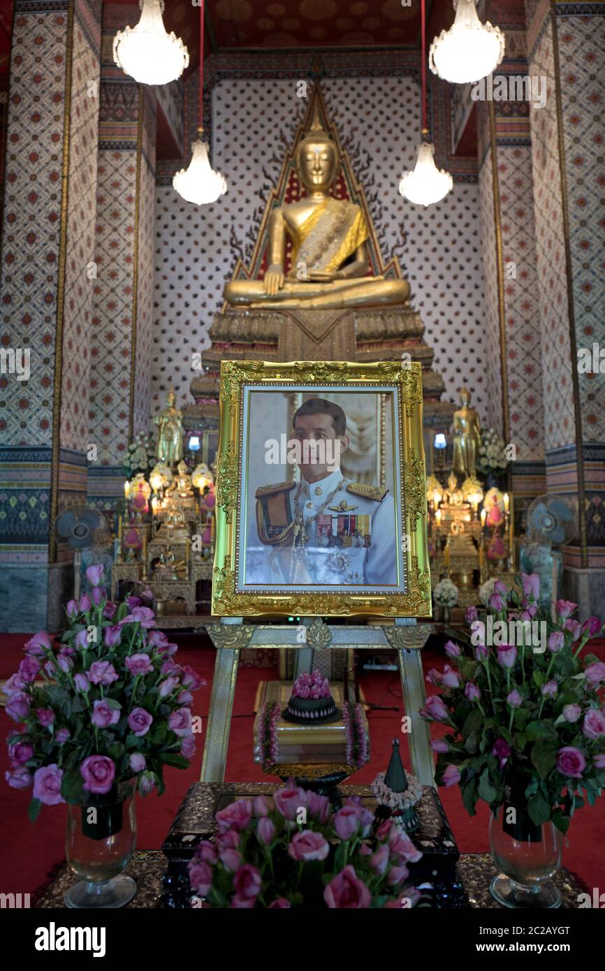 Famosa foto del rey de Tailandia, Vajiralongkorn, situada bajo una estatua de Buda de oro, dentro del templo Wat Arun, en Bangkok. Foto de stock