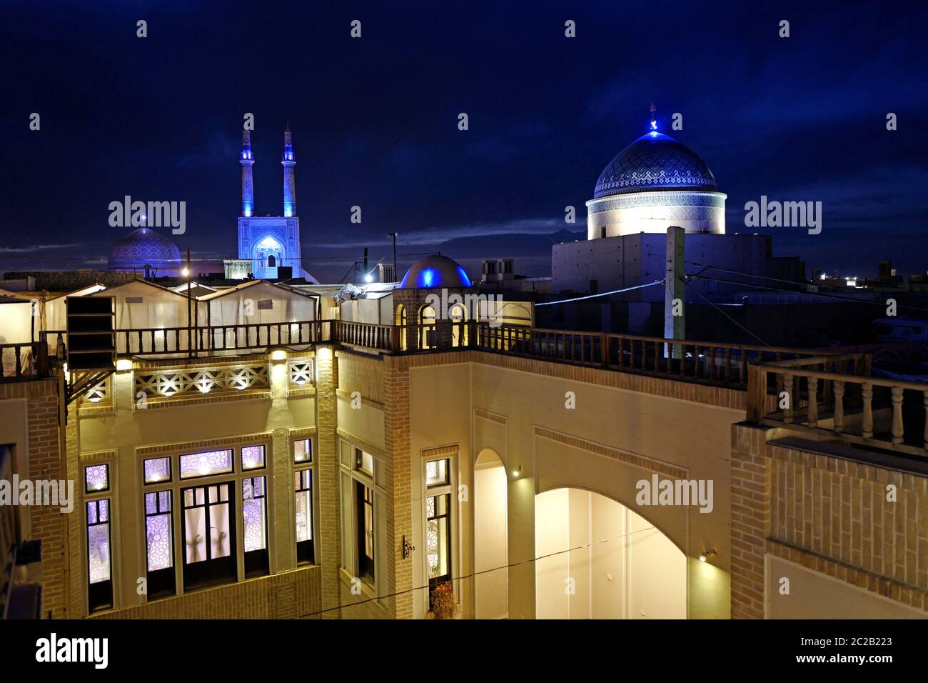 Vista nocturna de la ciudad con la Mezquita Jameh iluminada, en Yazd, Irán. Foto de stock