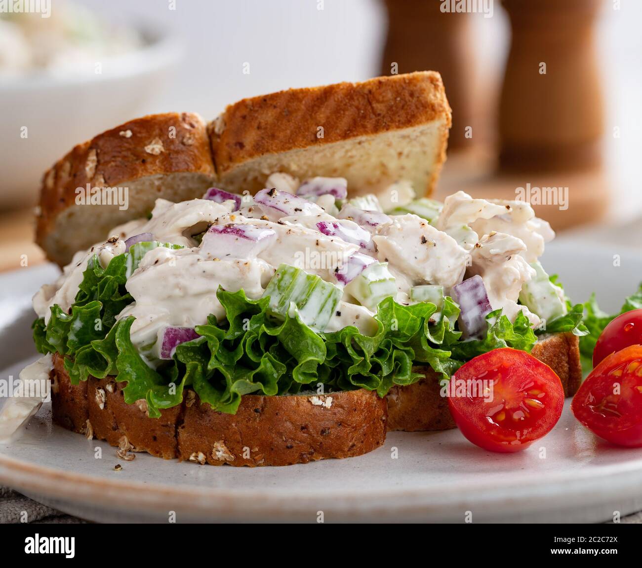 Sándwich de ensalada de pollo con lechuga en pan integral y tomates de uva  en un plato Fotografía de stock - Alamy