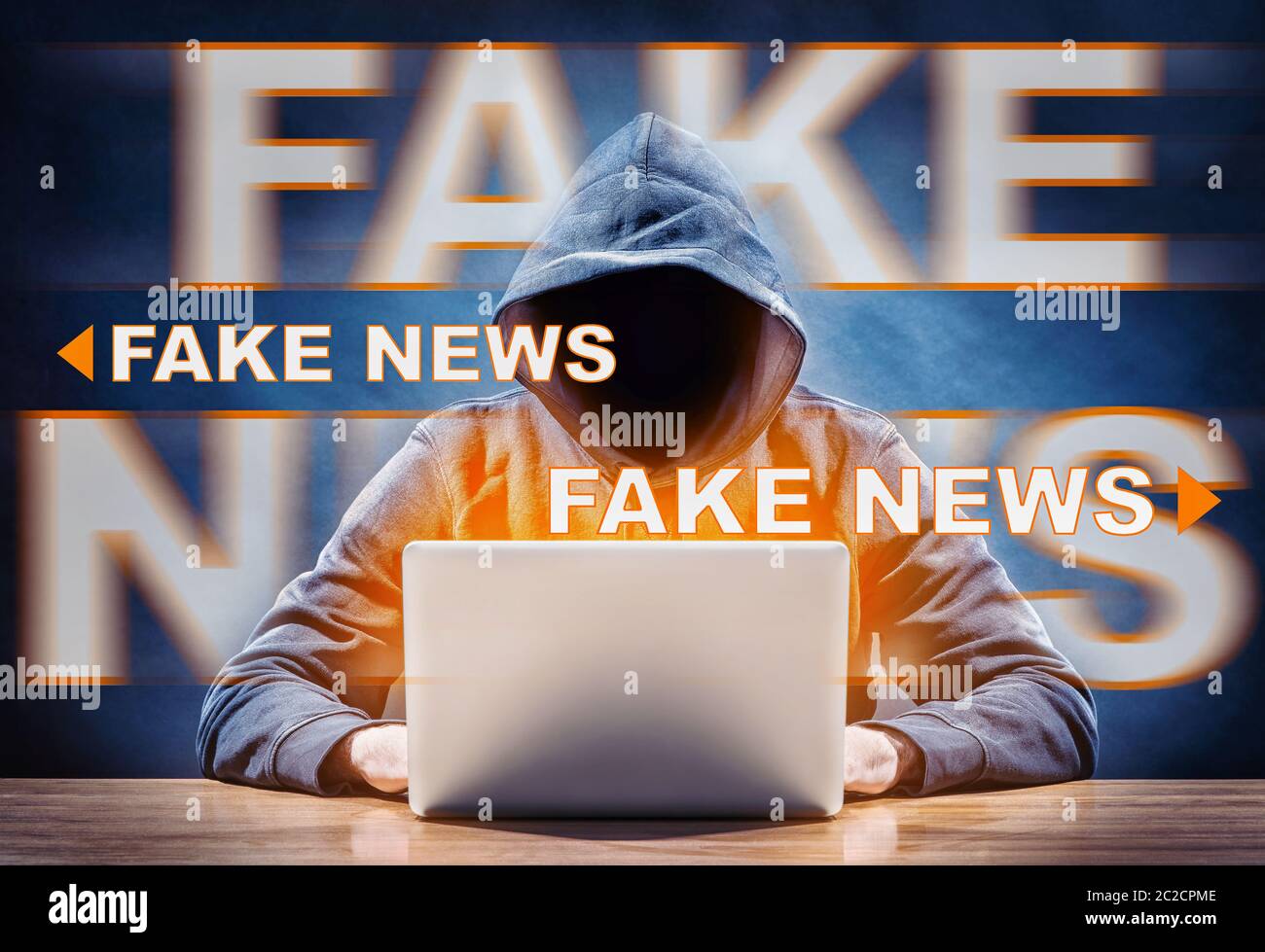 un hacker que difunde noticias falsas desde un ordenador Foto de stock