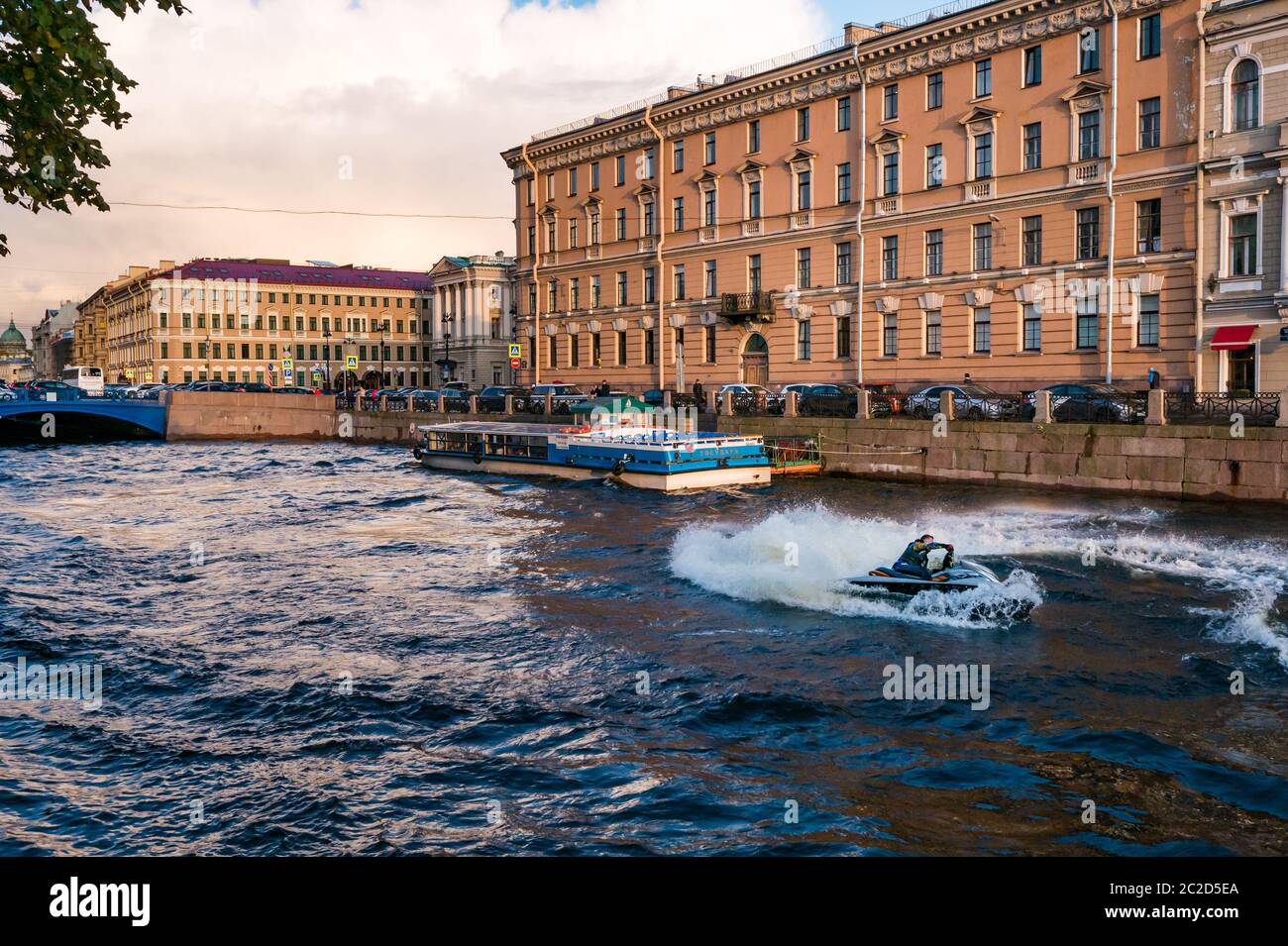 Moto acuática en canal creando ola cerca de Blue Bridge, Moyka River Embankment, San Petersburgo, Rusia Foto de stock